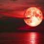 Luna roja con reflejo en el mar