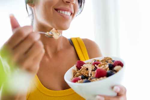 Mujer comiendo cereales con leche