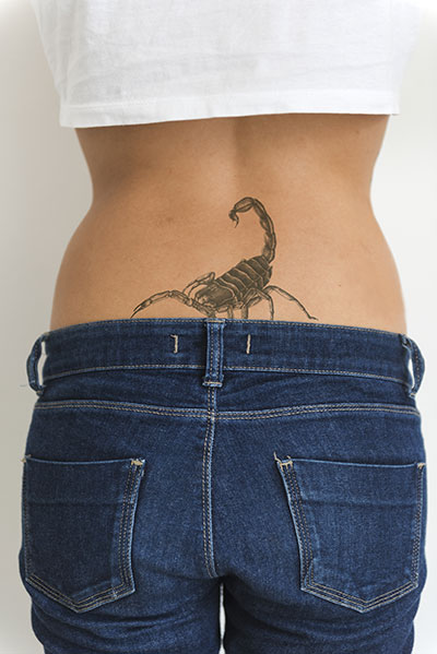 Mujer con tatuaje de escorpión en cadera